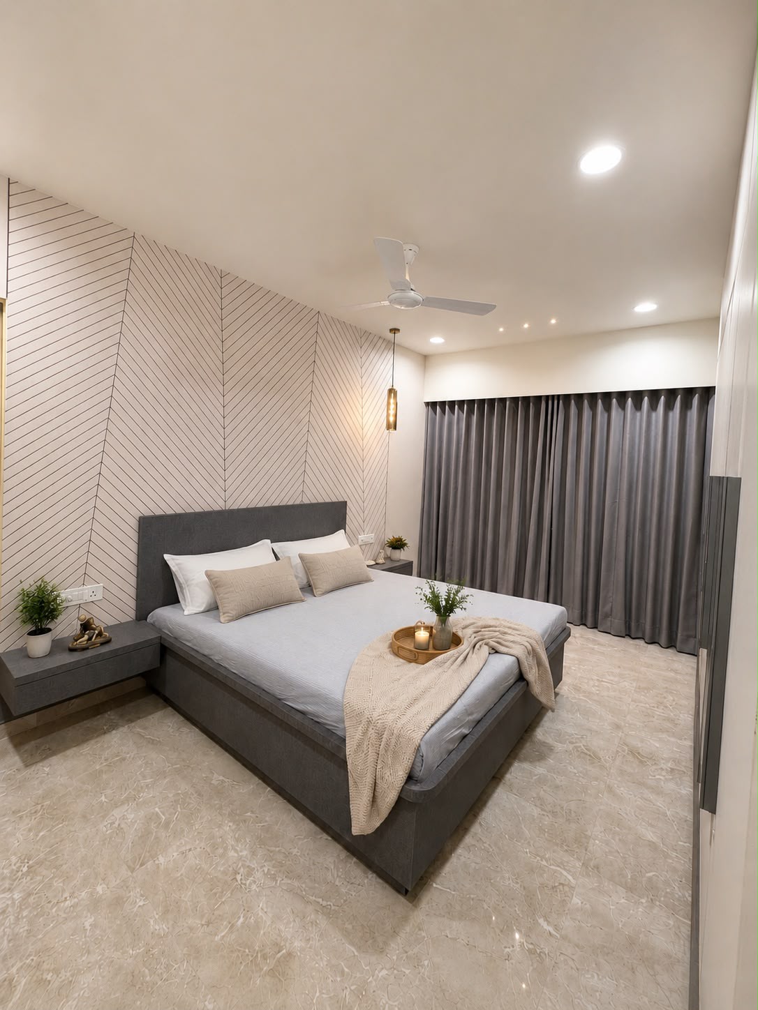 Bedroom with cream bedding, layered pillows, and a circular mirror