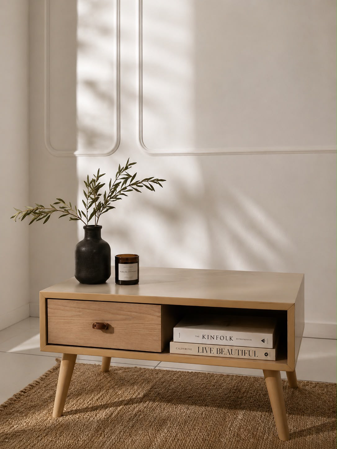 Custom-designed low side table with open shelf, books, and plant